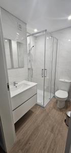 un bagno con doccia, lavandino e WC di Faro Main Avenue Apartment II a Faro