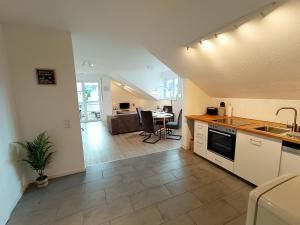 eine Küche und ein Wohnzimmer mit einem Waschbecken und einem Tisch in der Unterkunft Ferienwohnung am Ruhrtalradweg in Arnsberg in Arnsberg