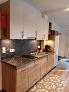 a kitchen with white cabinets and a black counter top at Ferienwohnungen Meister in Hinterhornbach