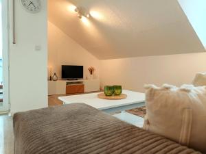 ein Wohnzimmer mit einem Sofa und einem TV in der Unterkunft Ferienwohnung am Ruhrtalradweg in Arnsberg in Arnsberg