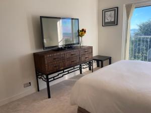 a bedroom with a dresser with a mirror and a bed at Home in Portishead