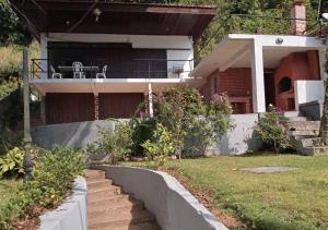 a house with a staircase in front of it at Casa das orquídeas ilha de Itacuruça in Itacuruçá