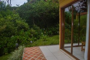 una puerta de cristal con vistas al jardín en Hotel Ficus - Monteverde, en Monteverde
