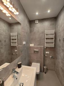 ein Badezimmer mit einem Waschbecken, einem WC und einem Spiegel in der Unterkunft Dwie sosny i świerk in Ustronie Morskie