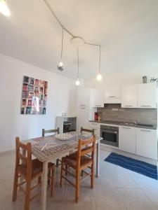 a kitchen with a table and chairs in a room at Antiche Mura Apartments"Cielo di Puglia" -2 matrimoniali, cucina,letto singolo e terrazzo in Turi