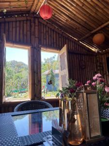 einen Tisch mit Blumen und ein Fenster in einem Zimmer in der Unterkunft Lacasa Luxury Stays in Shogi