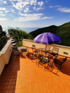 a patio with tables and chairs and an umbrella at Cristina Home in Vietri