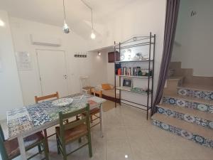 a dining room with a table and chairs and stairs at Antiche Mura Apartments"Cielo di Puglia" -2 matrimoniali, cucina,letto singolo e terrazzo in Turi