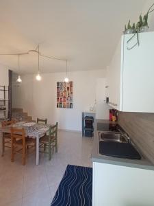 a kitchen and dining room with a table and a sink at Antiche Mura Apartments"Cielo di Puglia" -2 matrimoniali, cucina,letto singolo e terrazzo in Turi