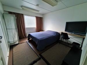 um quarto com uma cama e uma televisão de ecrã plano em Hostel Jailhouse Hamina em Hamina