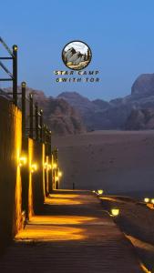 Una fila de luces en una acera por la noche en STAR CAMP & WiTH TOR en Wadi Rum