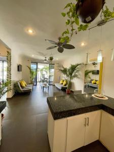 Marisol Beach في بلايا ديل كارمن: مطبخ وغرفة معيشة مع مروحة سقف