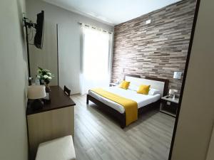 a bedroom with a bed and a brick wall at Domos La Corte Ghibellina in Iglesias