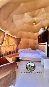 a bedroom with two beds and a couch and a table at RUM STARDUST lUXURY CAMP in Wadi Rum