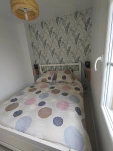 a small bedroom with a bed with polka dots at Entre terre et mer in Camiers