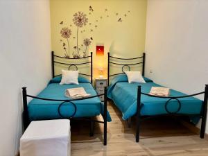 2 camas con sábanas azules en una habitación en Bouganville, en Olmedo