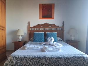 ガウシンにあるHostal Breñaverdeのベッドルーム1室(ベッド1台に白鳥のタオル2枚付)