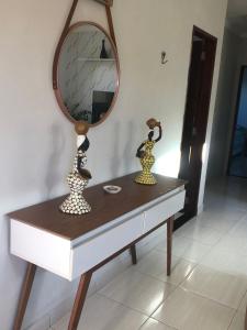 een kaptafel met een spiegel en twee vazen erop bij Recanto 111 in Serra de São Bento