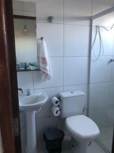een witte badkamer met een toilet en een wastafel bij Recanto 111 in Serra de São Bento
