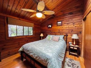 a bedroom with a bed in a log cabin at Hale Sweet Hale as seen on HGTV in Volcano