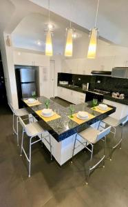 a kitchen with a large island with chairs and a table at Marisol Beach in Playa del Carmen