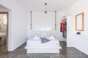a white bedroom with a bed and a mirror at Alisahni Studio Sea View in Paleochori