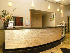 a lobby with a brick counter and a mirror at Hotel Elevado in Porto Alegre