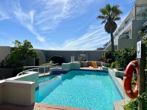 a swimming pool with a slide and a playground at Dolphin Beach Cabana in Table View