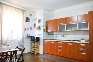 cocina con armarios de madera, mesa y comedor en Seaside House en Vietri