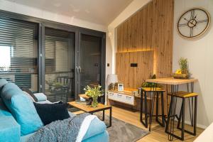 a living room with a blue couch and a kitchen at Otulina Błonie in Klukowo