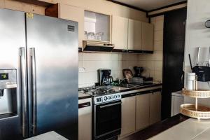 kuchnia z lodówką i kuchenką ze stali nierdzewnej w obiekcie Cozy Apartment in Maracaibo w Maracaibo