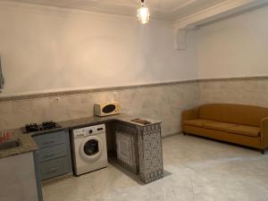 ein Wohnzimmer mit einer Waschmaschine und einem Sofa in der Unterkunft La maison du lac in Alger