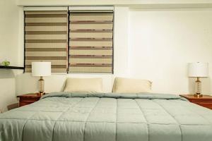 a bedroom with a large bed with two lamps at Cozy Apartment in Maracaibo in Maracaibo