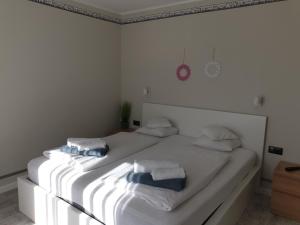 een slaapkamer met een wit bed en handdoeken bij Pokoje Sandra I in Łeba
