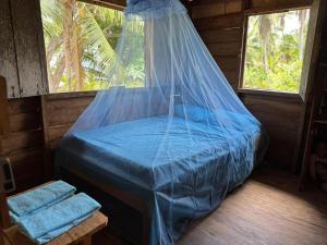 a bed with a net in a room with windows at HOSPEDAJE DOÑA NEL in El Valle