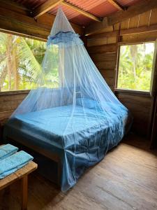 a bed with a net in a cabin at HOSPEDAJE DOÑA NEL in El Valle