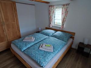 a bedroom with a bed with two towels on it at Ferienwohnungen Urlaubsglück in Kurort Gohrisch