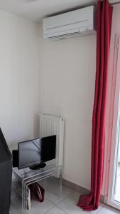 Habitación con TV y cortina roja. en Appartement Fodéré 2, en Niza