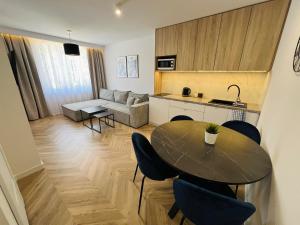 a kitchen and a living room with a table and chairs at KarvalSea APARTAMENTY in Karwia