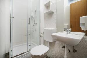 a bathroom with a toilet and a shower and a sink at Rooms Orion in Vodice