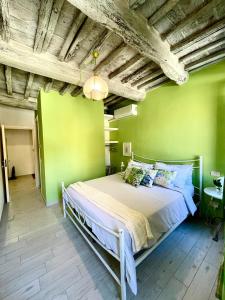 una camera con un letto su una parete verde di La casa dei Mimmi a Città della Pieve