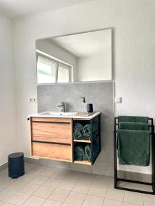 a bathroom with a sink and a mirror at DAS AMBIENTE II Komfortables Wohnerlebnis mit Moselromantik - Herzlich Willkommen - in Zell an der Mosel