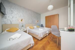 a hotel room with two beds with towels on them at Rooms Orion in Vodice