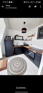 a kitchen with a table and a rug on the floor at Chez Valérian, gare de Chantilly in Chantilly