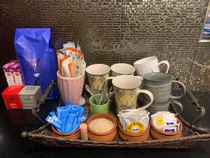 ein Korb mit Tassen und anderen Gegenständen auf einem Tisch in der Unterkunft Whitfords Delight Homestay in Perth