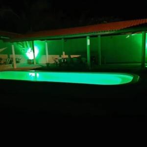 a green room with a table and chairs at night at Pousada Vela dos Ventos in Praia de Moitas +33 photos