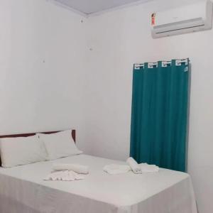 a bedroom with a bed with a blue shower curtain at Pousada Vela dos Ventos in Praia de Moitas