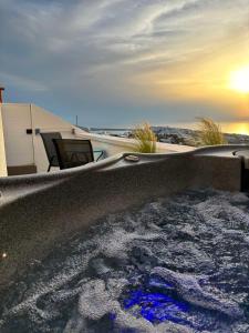 a bath tub filled with water next to a building at Sunset Paradise Oia in Oia