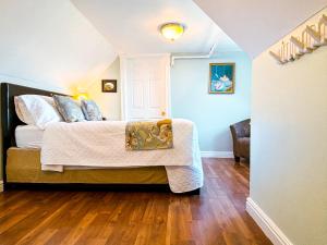 una camera da letto con letto, pareti blu e pavimenti in legno di The Eden Hall Inn a Charlottetown