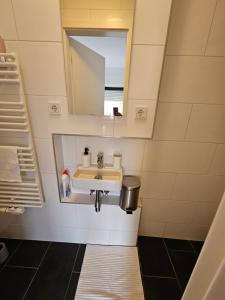 a bathroom with a sink and a mirror at Chambre d'Hôte Confort Ettelbruck in Ettelbruck